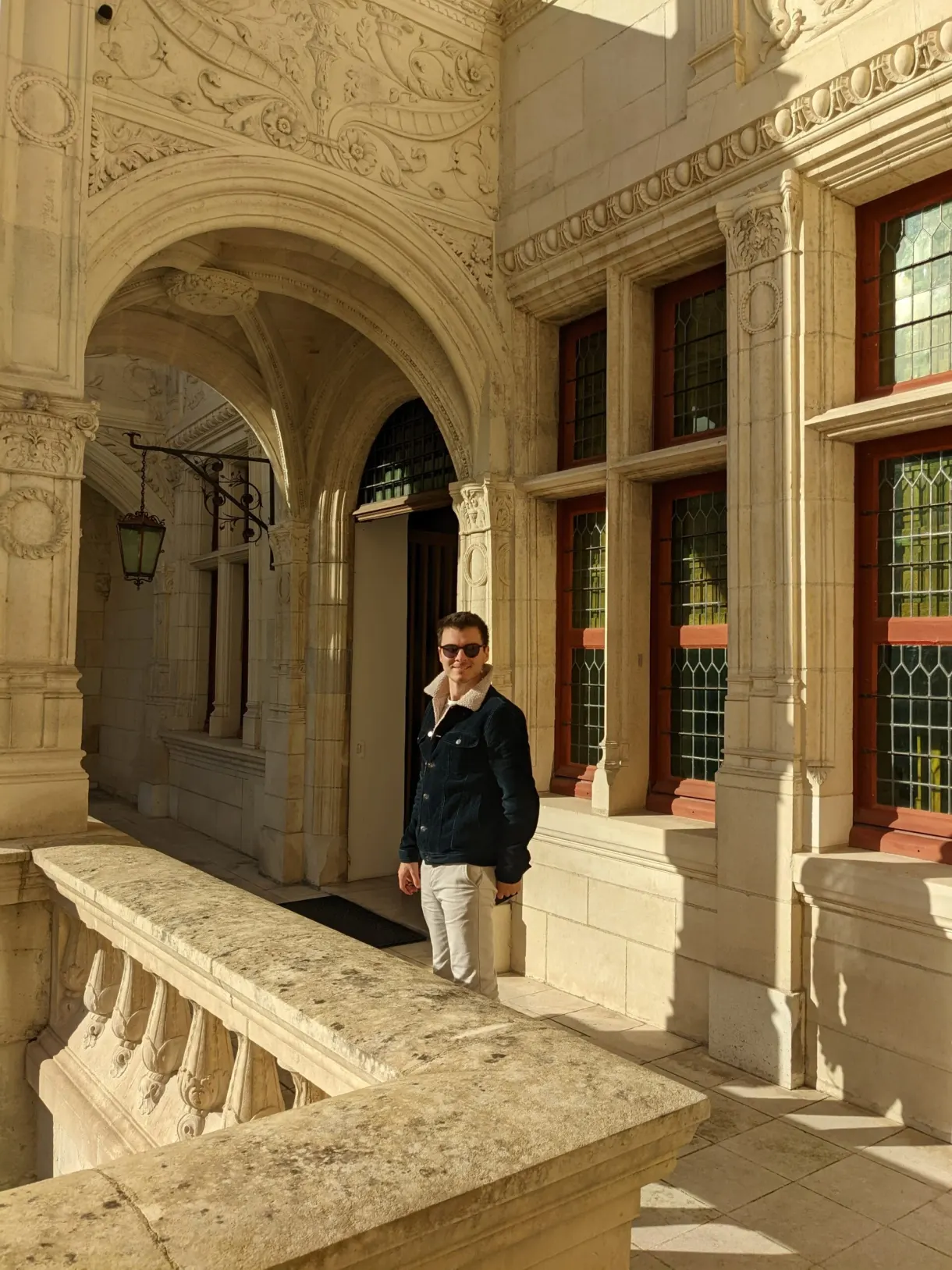 Galerie voûtée Renaissance où un visiteur téléphone au soleil