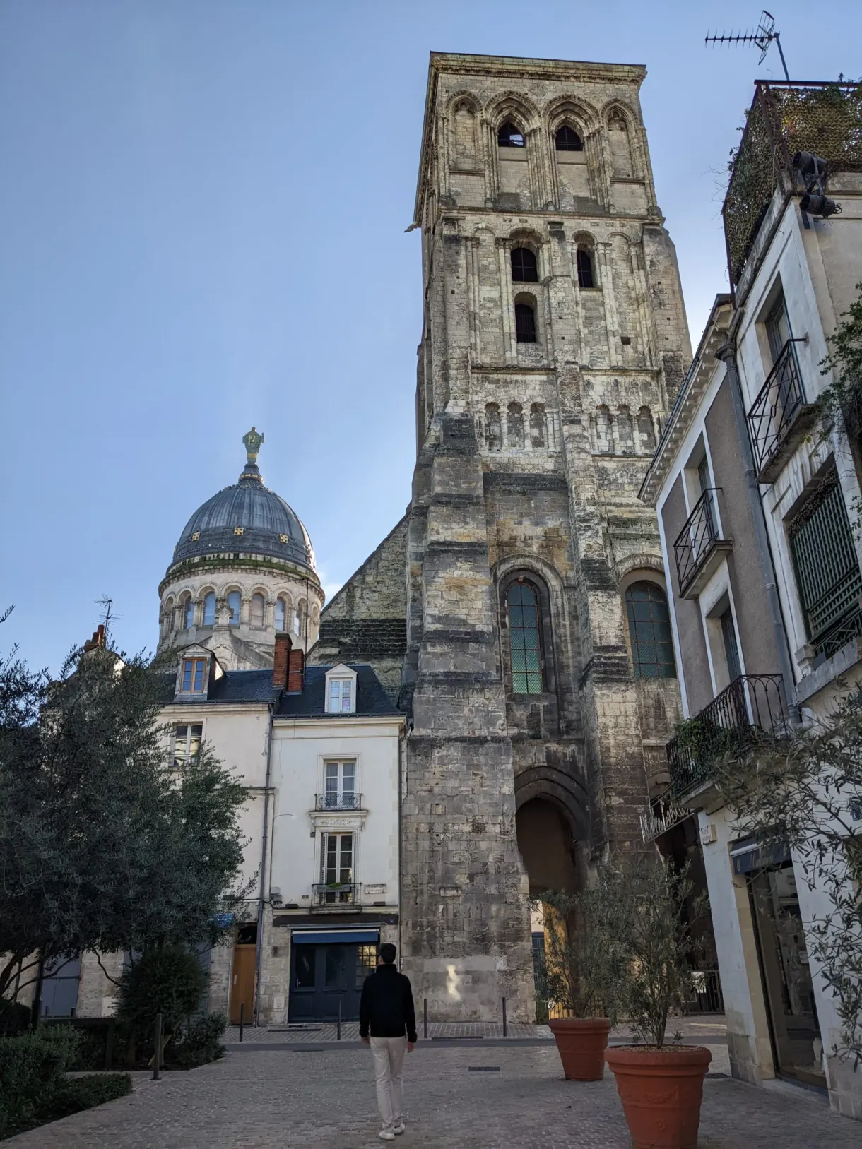 Tour romane et coupole bleue au bout d'une placette tranquille