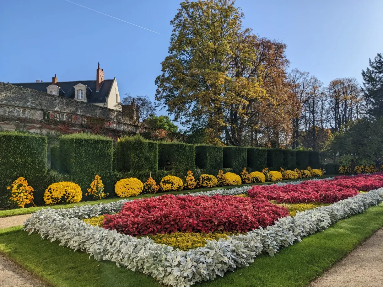 Jardin à la française aux massifs roses, blancs et jaunes