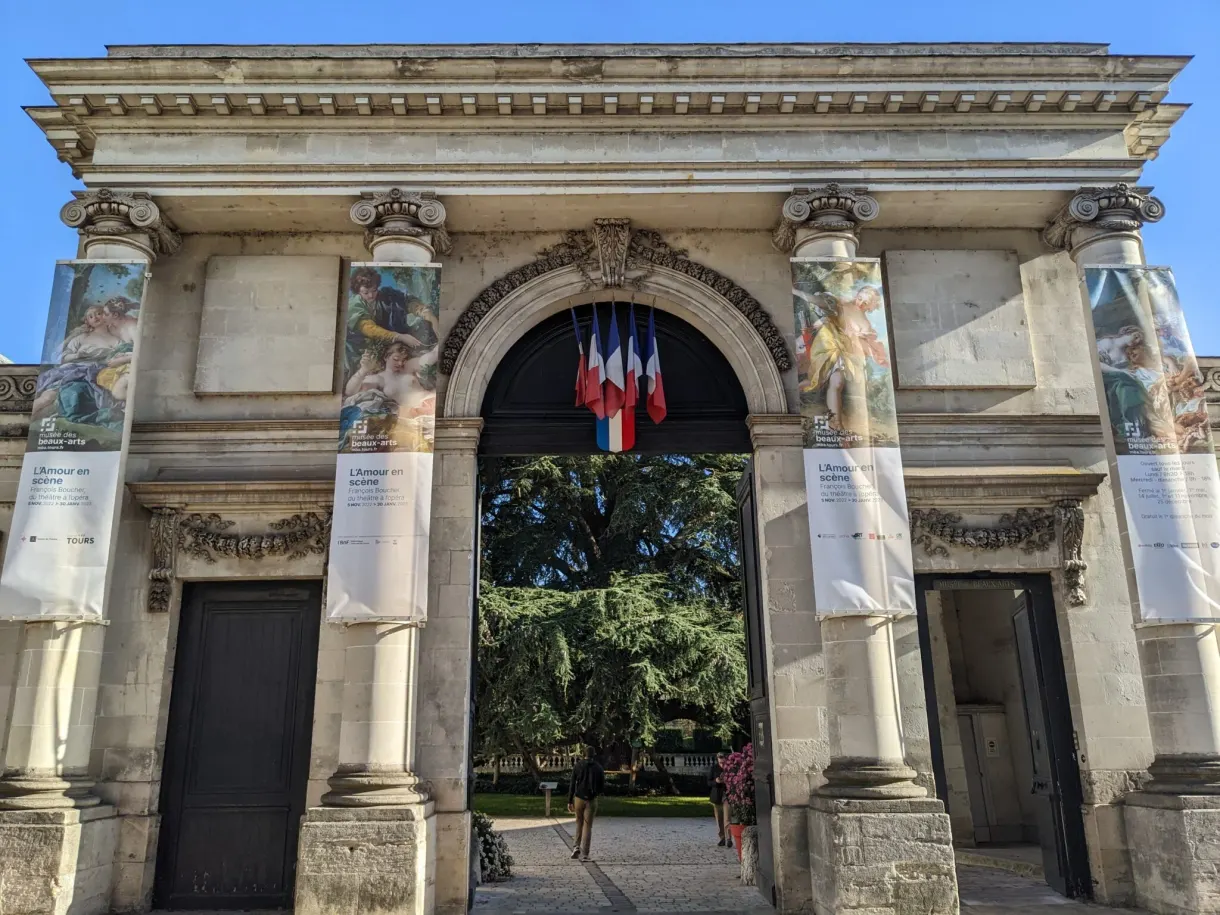 Portique monumental habillé d'affiches d'exposition et de drapeaux