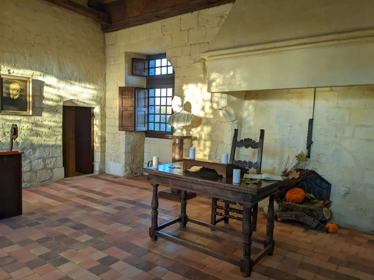 Chambre ancienne meublée d'une table de bois et d'un buste