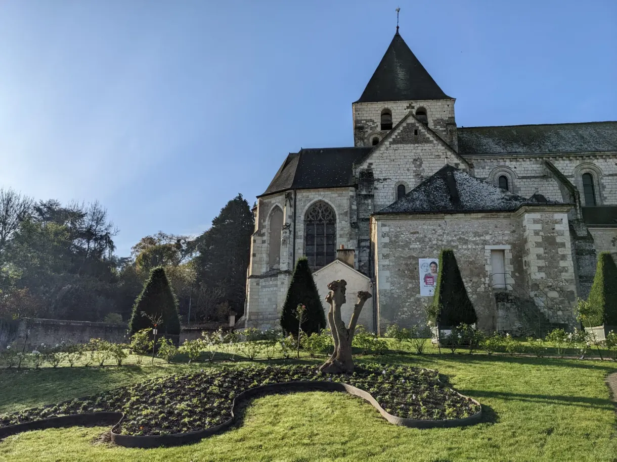 Église en pierre et topiaire en forme d'animal dans le jardin