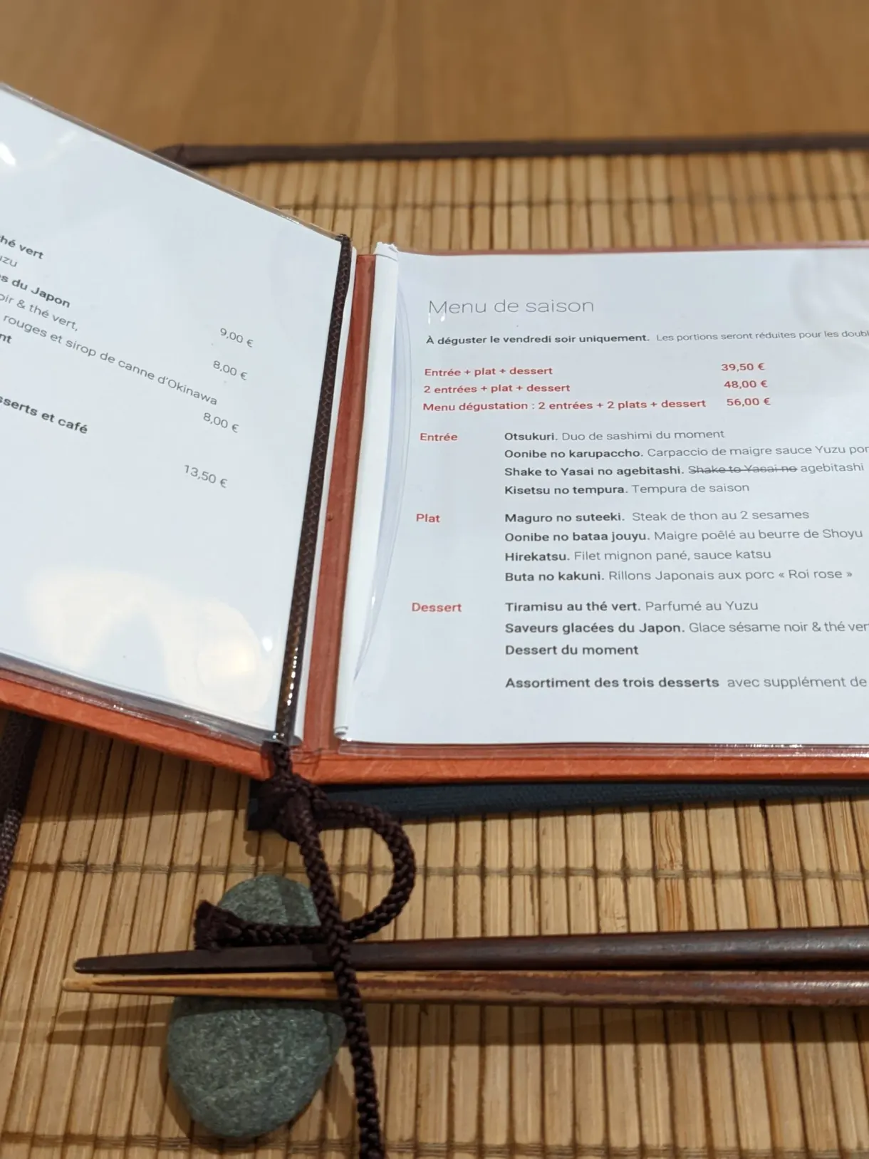 Menu ouvert sur une table dressée avec baguettes japonaises