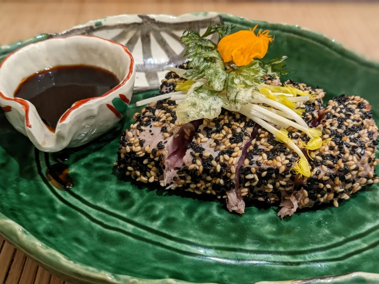 Tataki de thon et riz noir sur assiette verte, sauce soja