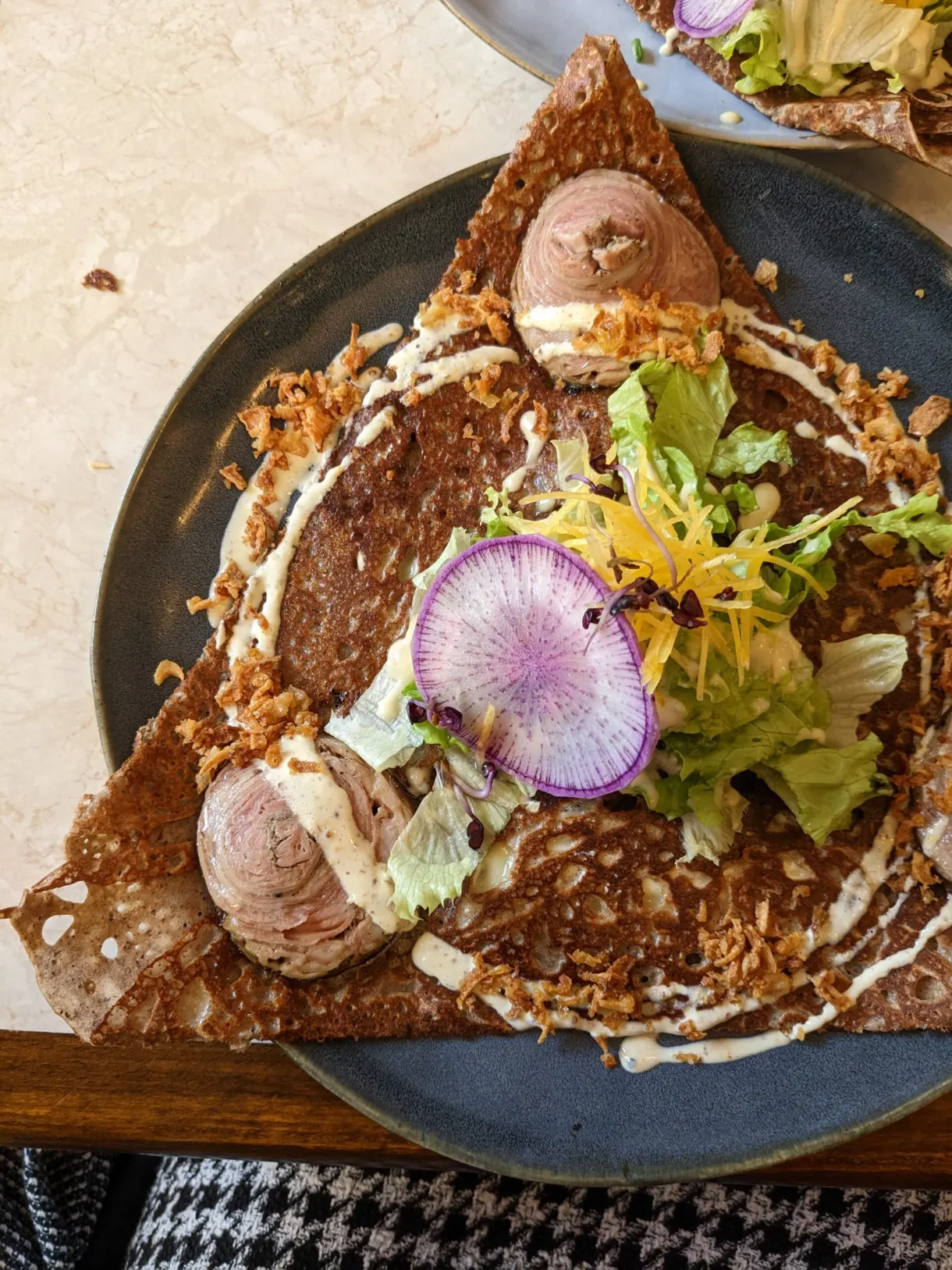 Galette garnie de radis, salade et boules de glace