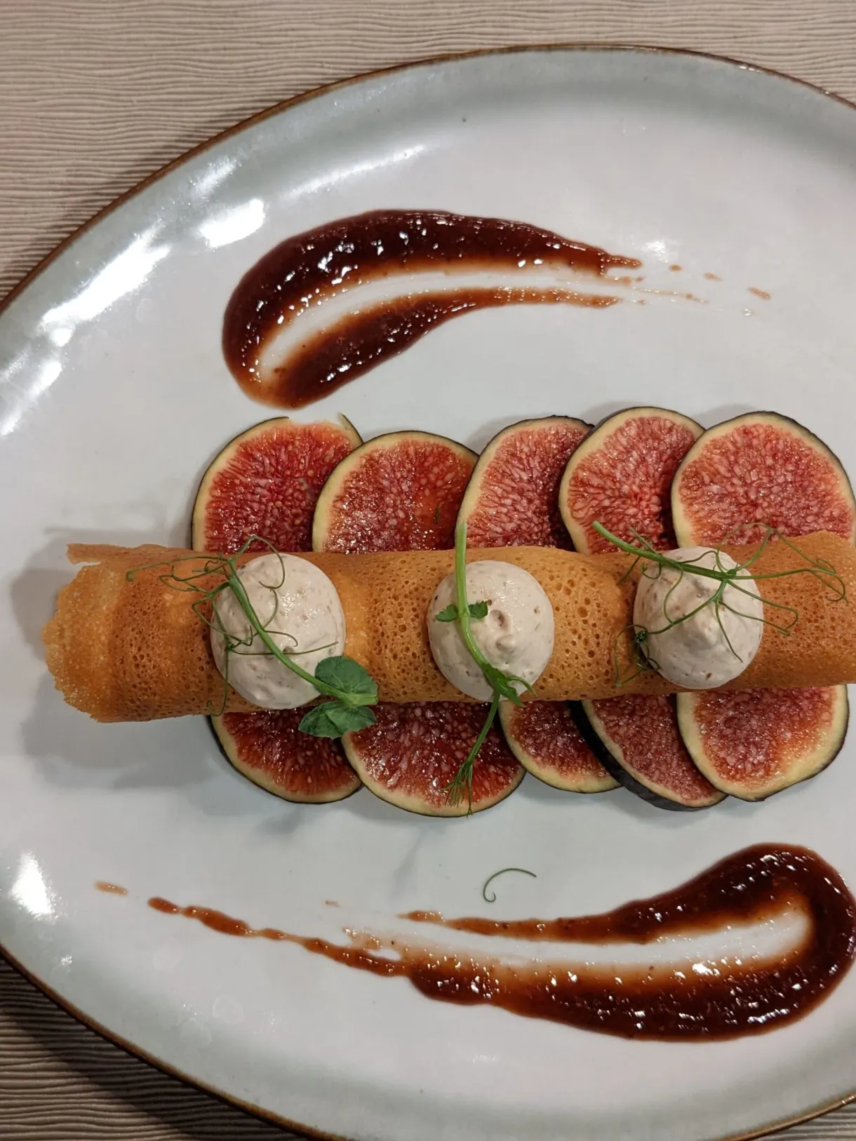 Figues et quenelles alignées entre deux traits de sauce