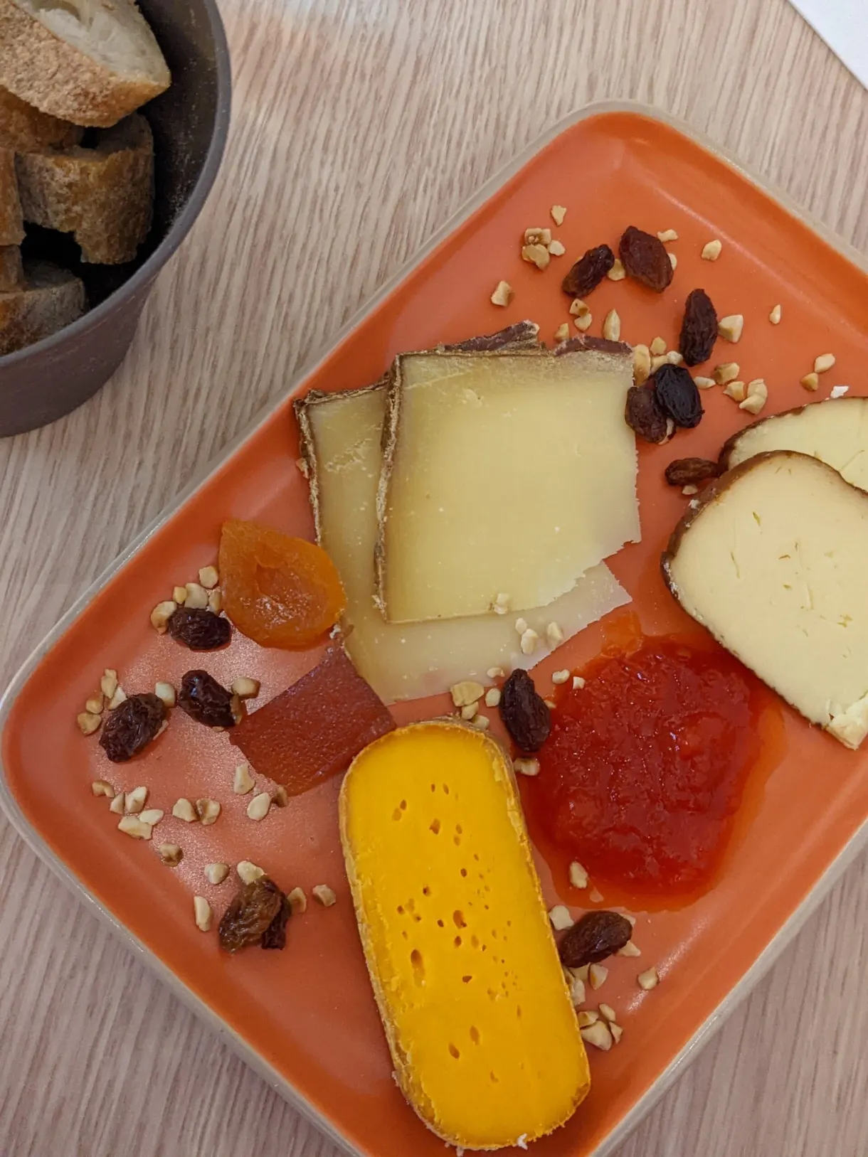 Fromages, pâte de fruits et fruits secs sur plateau orange