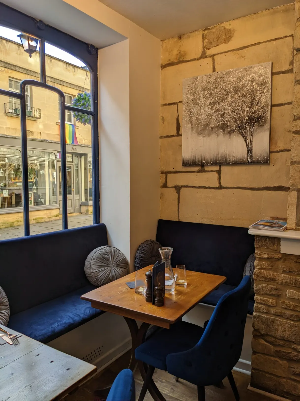 Banquettes bleues et mur de pierre d'un salon de thé