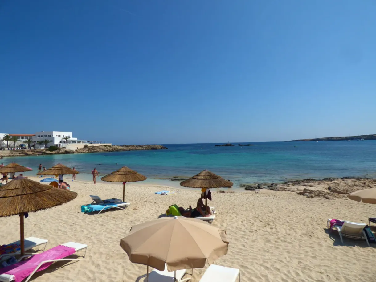 Parasols de paille et transats alignés sur la plage