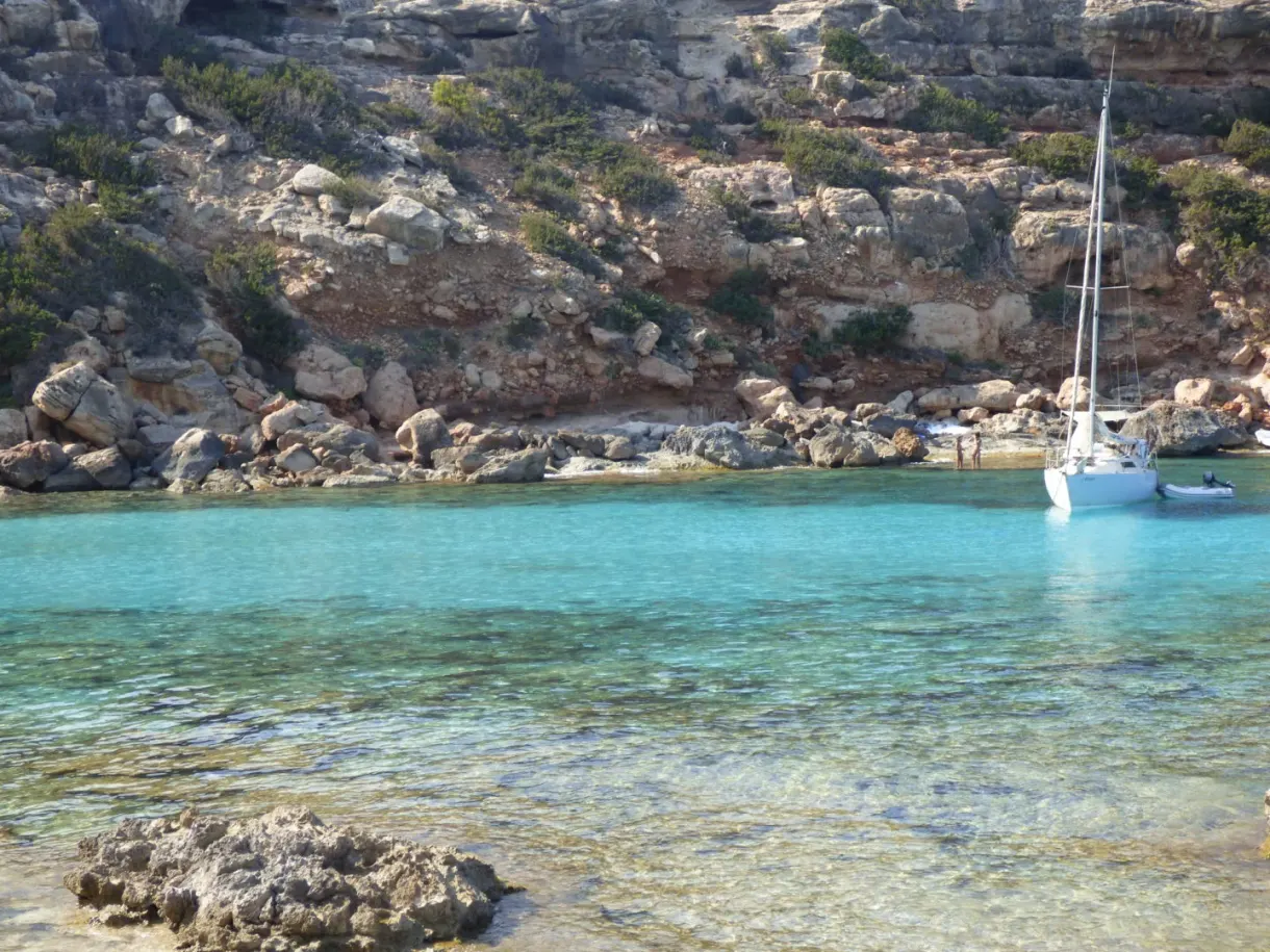 Voilier mouillé dans une anse aux parois rocheuses