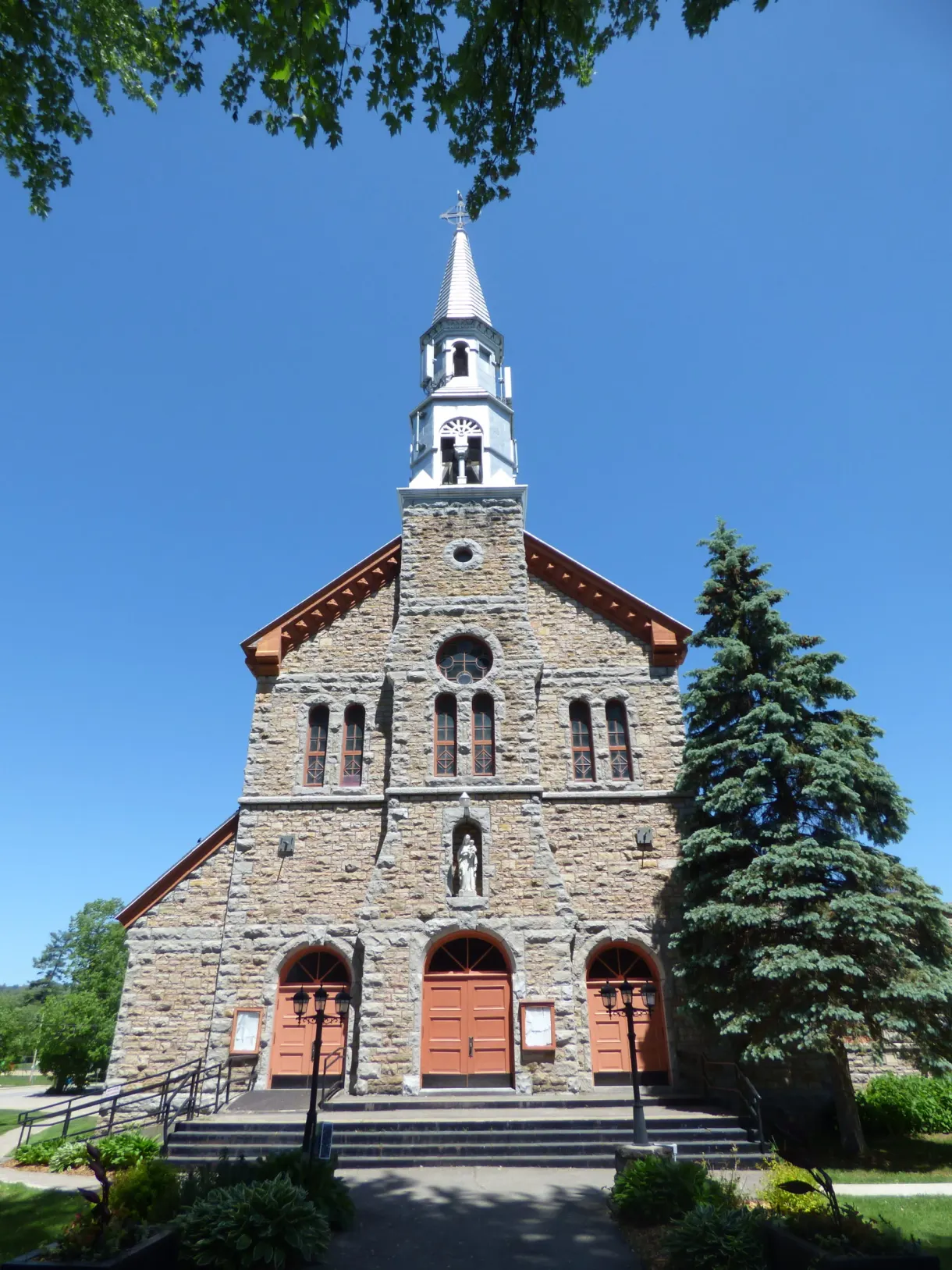 Église de pierre au clocher blanc de Montebello