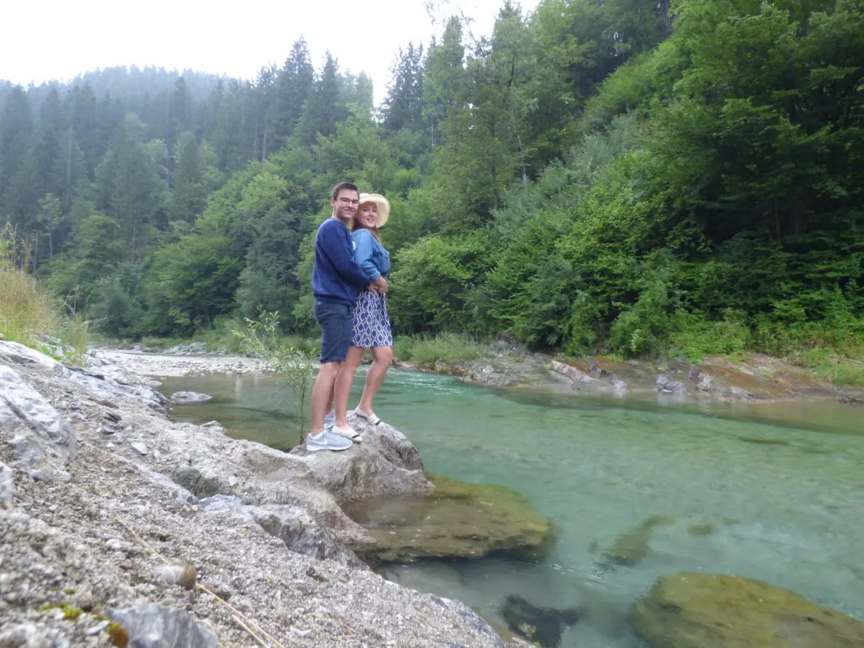 Couple enlacé sur un rocher au bord de la rivière