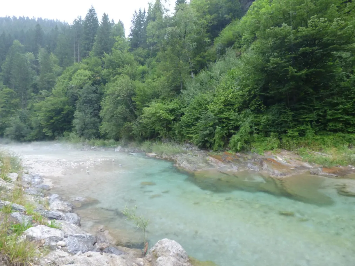 Rivière turquoise coulant entre des berges de galets