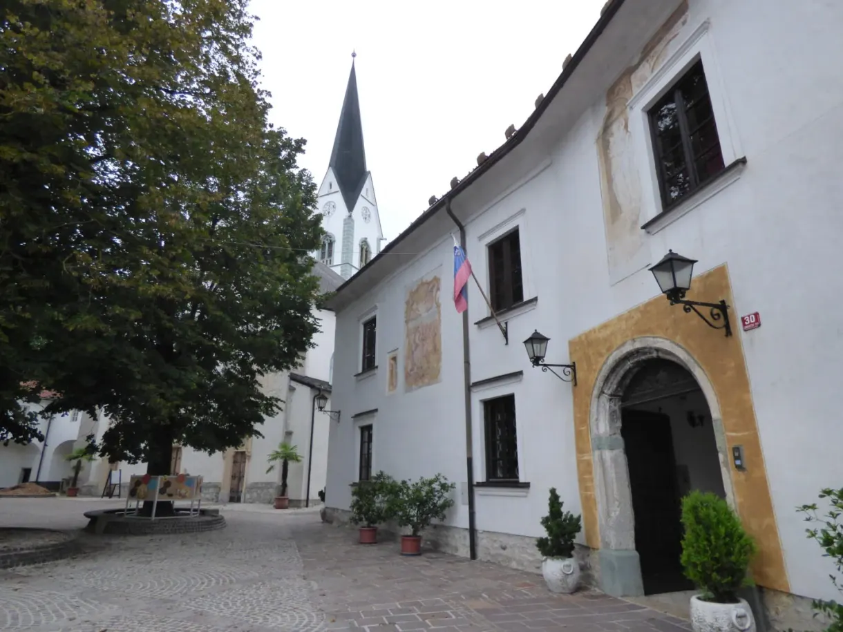Place pavée devant une église et un portail jaune