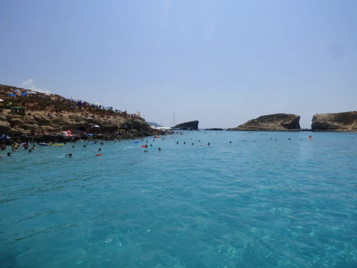 Baigneurs dans le lagon face à l'îlot rocheux