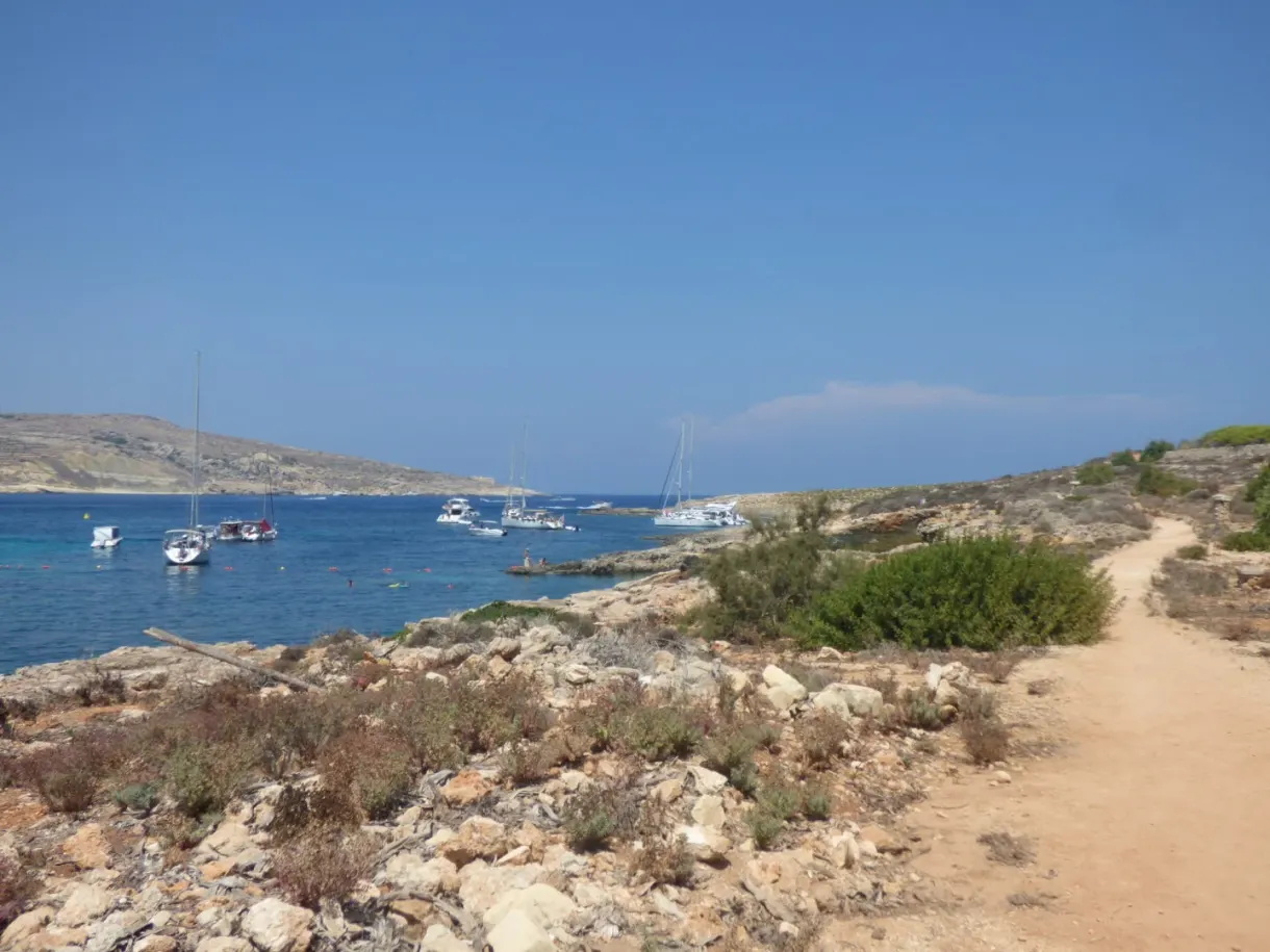 Voiliers au mouillage devant une pointe rocailleuse