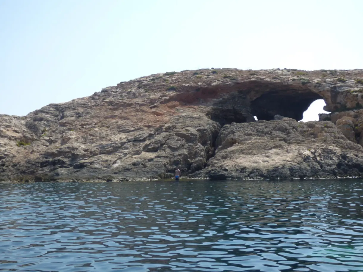 Arche naturelle percée dans la roche au ras de l'eau