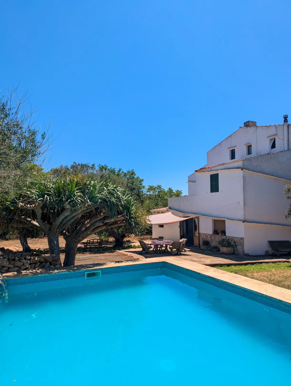 Piscine bleue au pied de la maison blanche