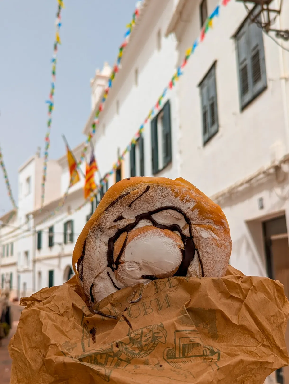 Viennoiserie au chocolat tenue dans une ruelle blanche