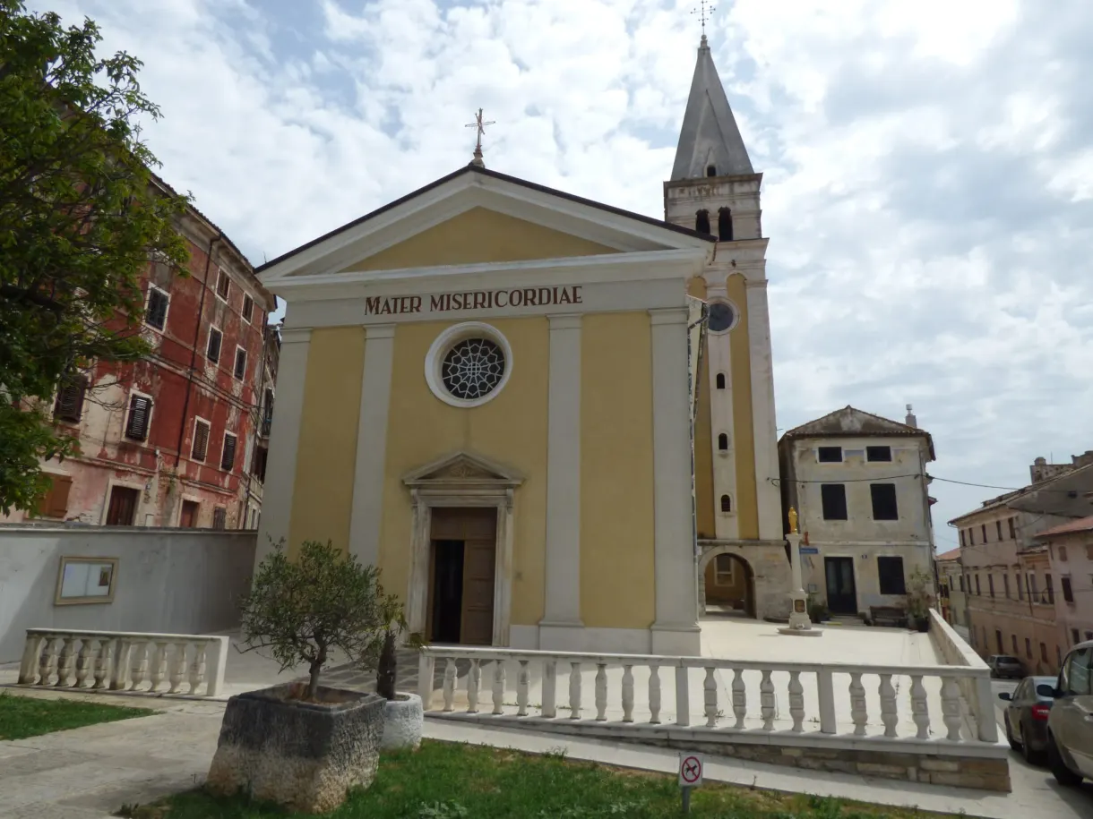 Église jaune Mater Misericordiae et son clocher de pierre à Buje