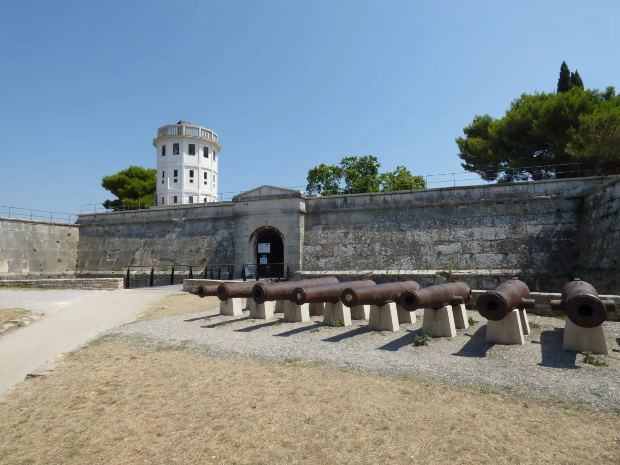 Canons alignés devant le rempart et la tour blanche de la forteresse de Pula