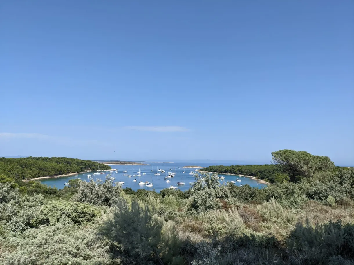 Bateaux au mouillage dans une baie bordée de maquis, Kamenjak