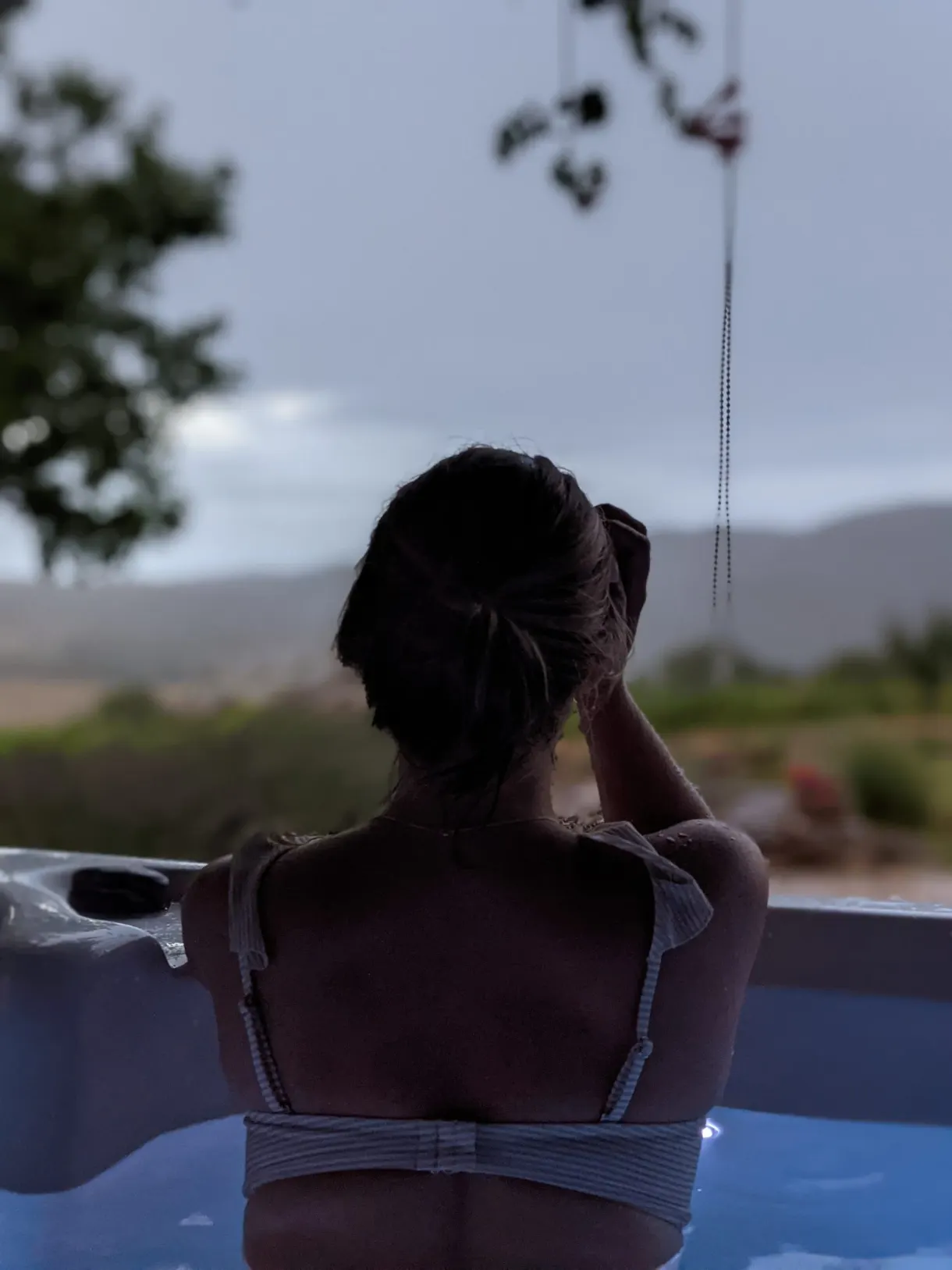 Femme de dos dans le bain à remous regardant les collines
