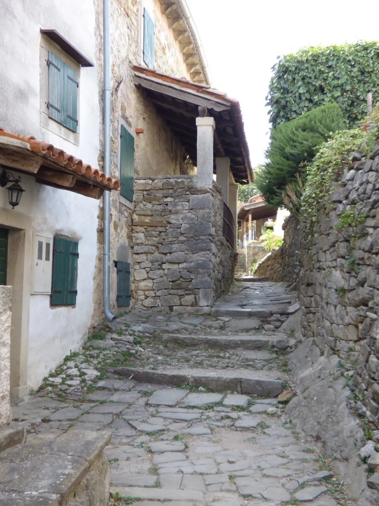 Ruelle en escalier bordée de murs de pierre sèche à Hum