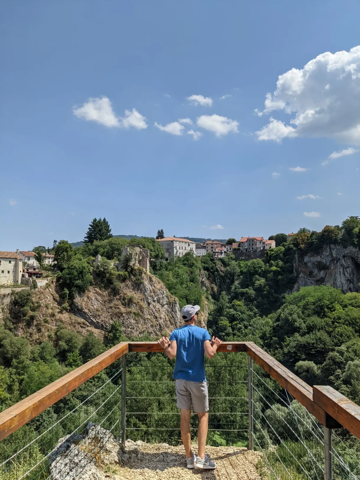 Homme accoudé à la passerelle du belvédère au-dessus du gouffre de Pazin