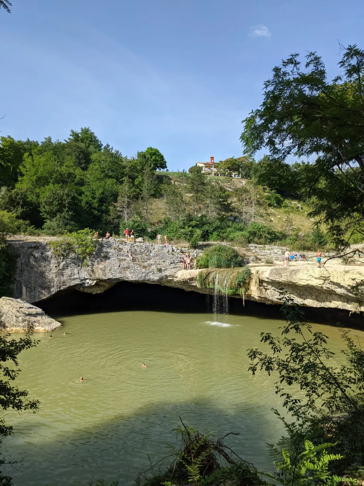 Eau verte et cascade au fond de la grotte du gouffre de Pazin