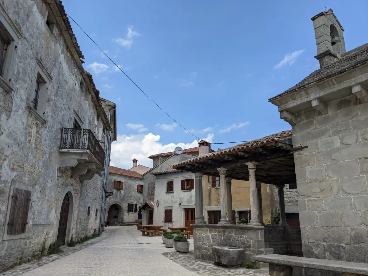 Maisons de pierre et clocheton le long d'une rue de Gračišće