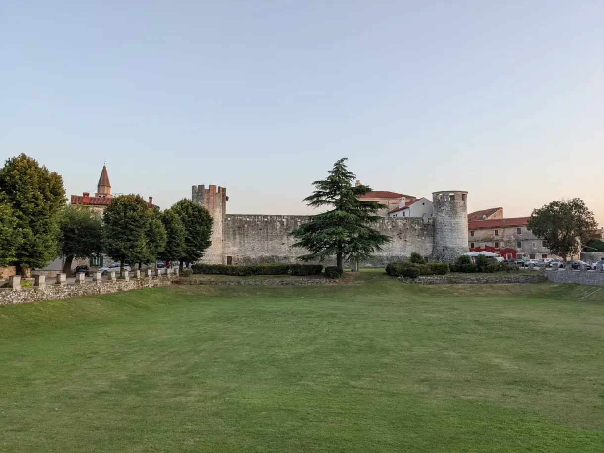 Vaste pelouse devant les remparts crénelés du château de Svetvinčenat