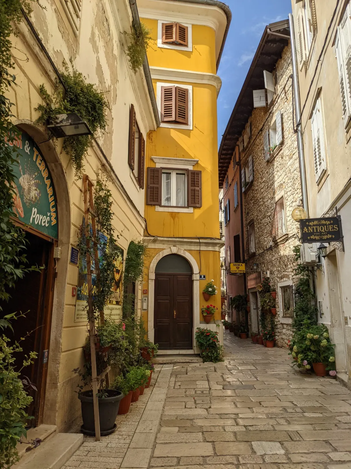 Rue commerçante de Poreč et sa maison jaune aux volets bruns