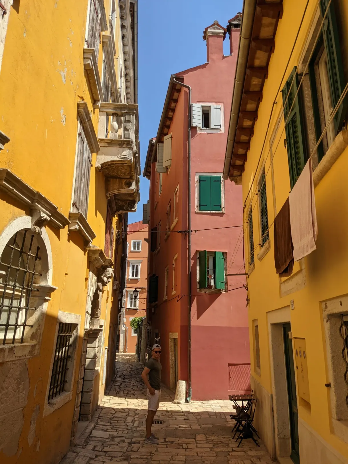 Ruelle aux façades jaune, rose et ocre du vieux Rovinj
