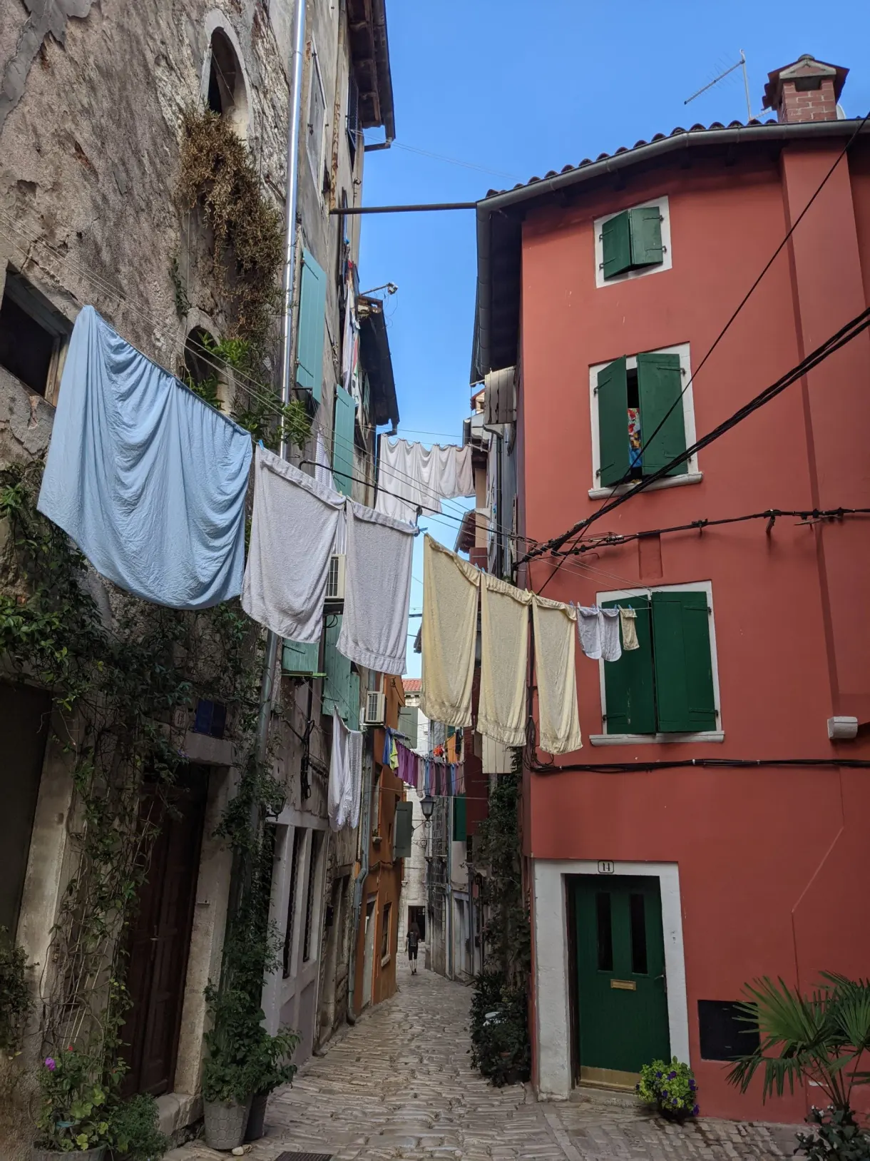 Linge étendu en travers d'une ruelle aux façades rouges de Rovinj