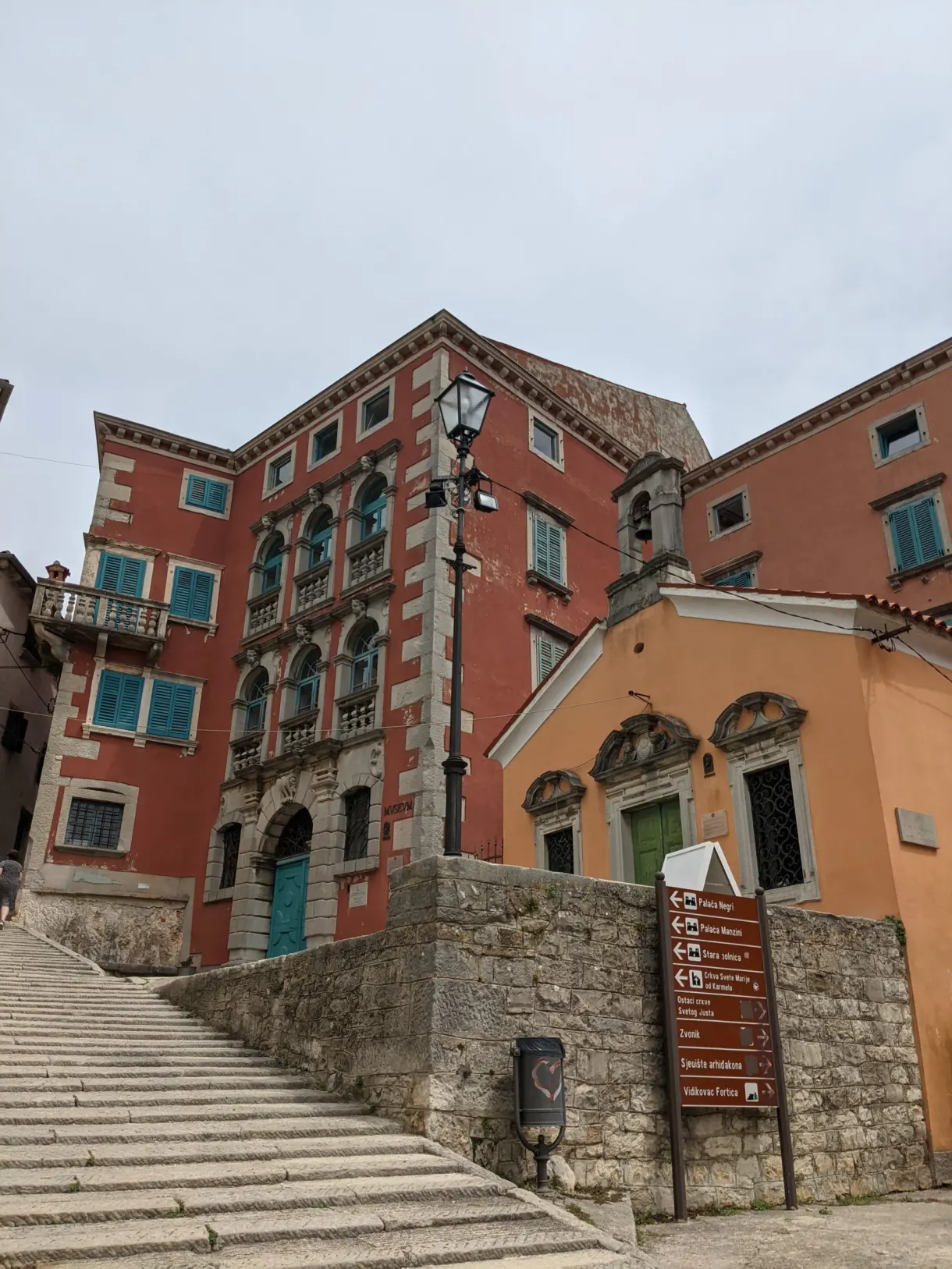 Palais rouge et large escalier de pierre dans la vieille ville de Labin