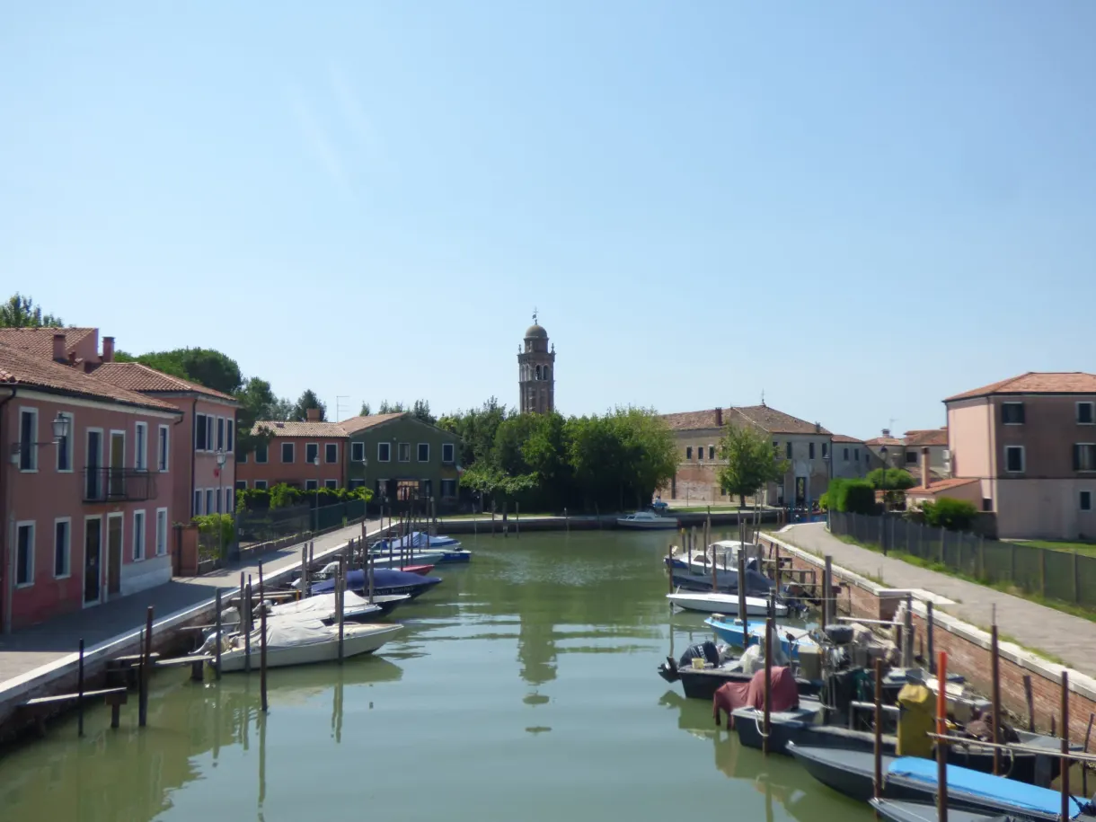 Mazzorbo canal lined with boats, bell tower in the background