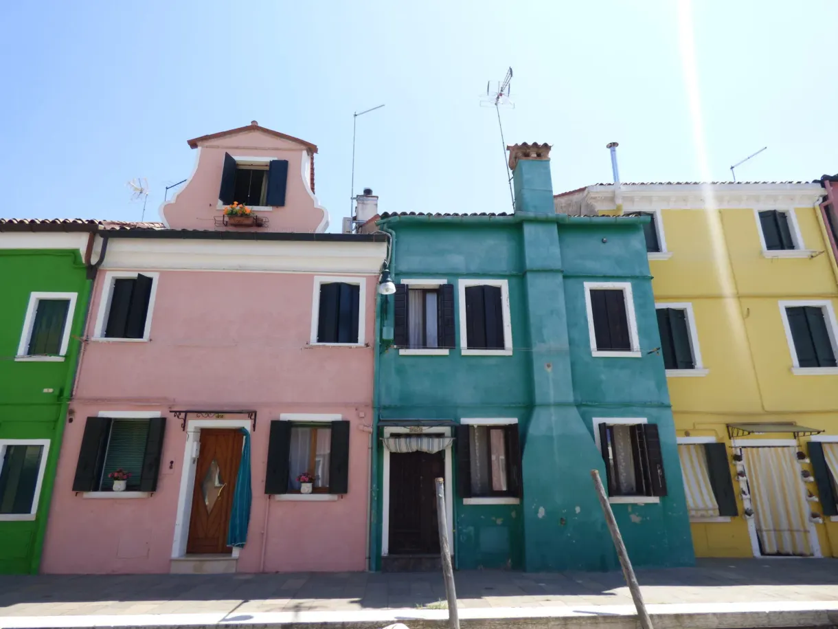 Pink, green and yellow facades lined up under a blue sky