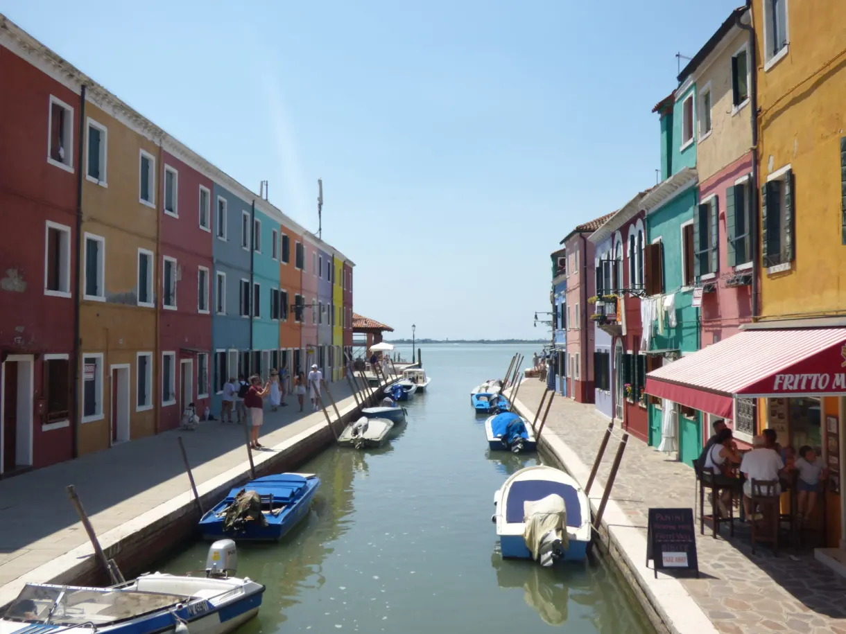 Burano canal lined with bright houses and a terrace