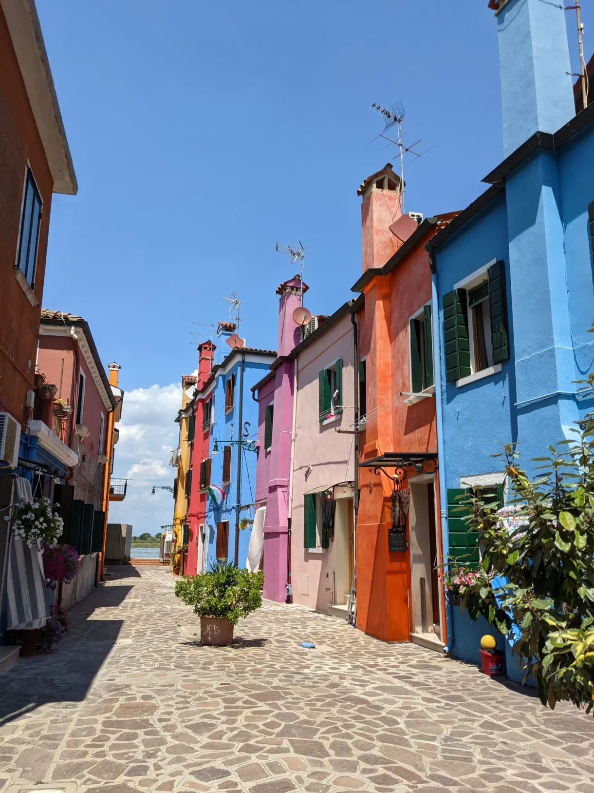 Cobbled lane lined with blue, pink and orange houses