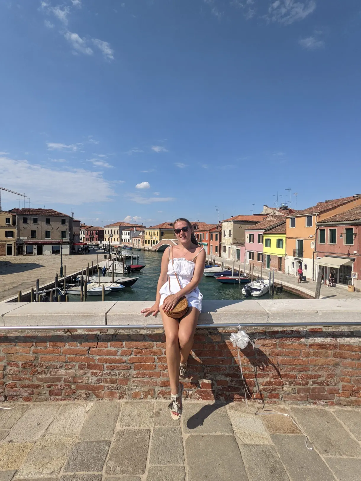 Sitting on a brick wall at the edge of the canal
