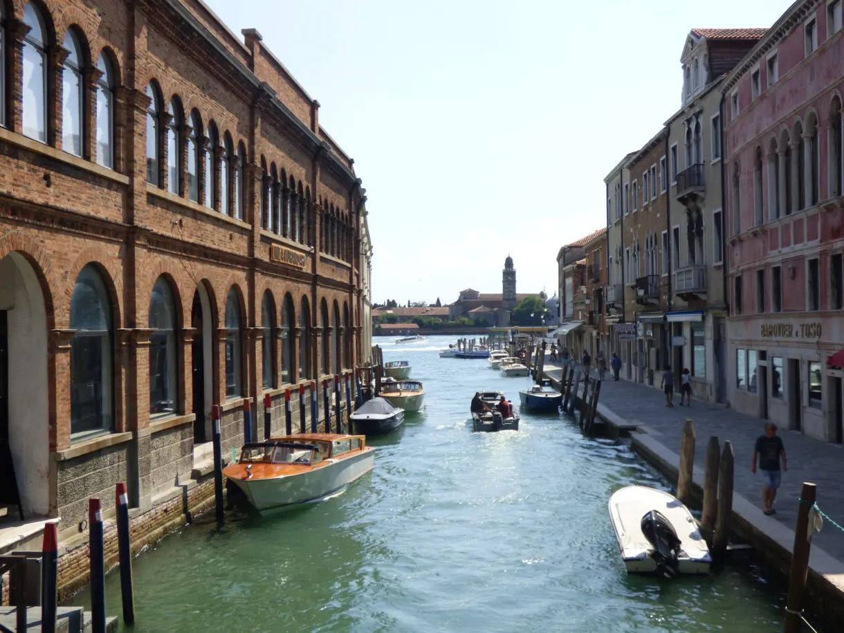 Long arcaded building at the edge of a busy canal