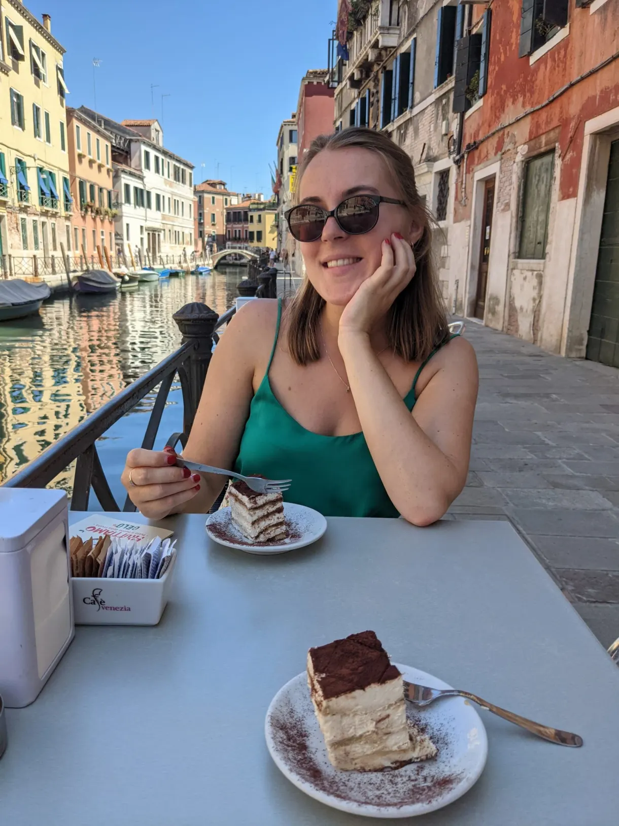 Seated on a terrace in front of a tiramisu, canal in the background