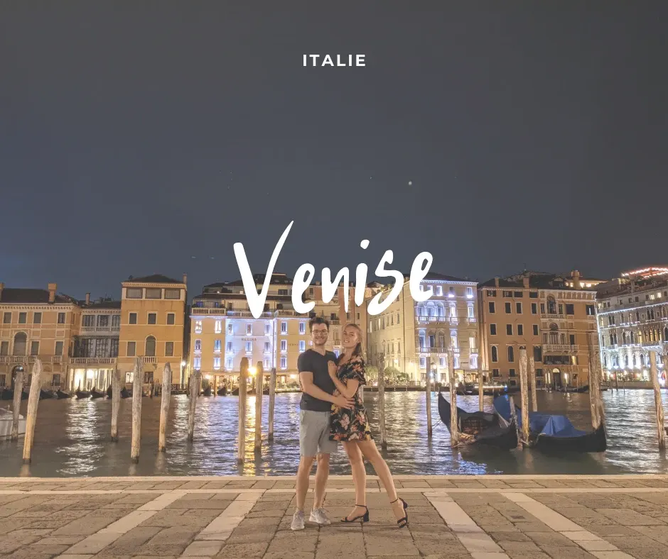 Couple posing in front of the Grand Canal lit up at nightfall