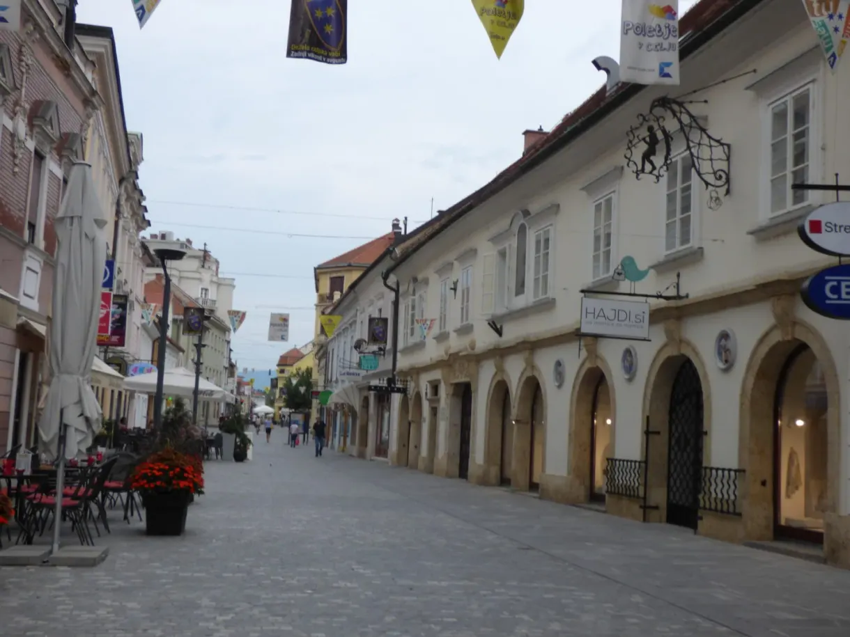 Rue commerçante bordée d'arcades et de terrasses fleuries