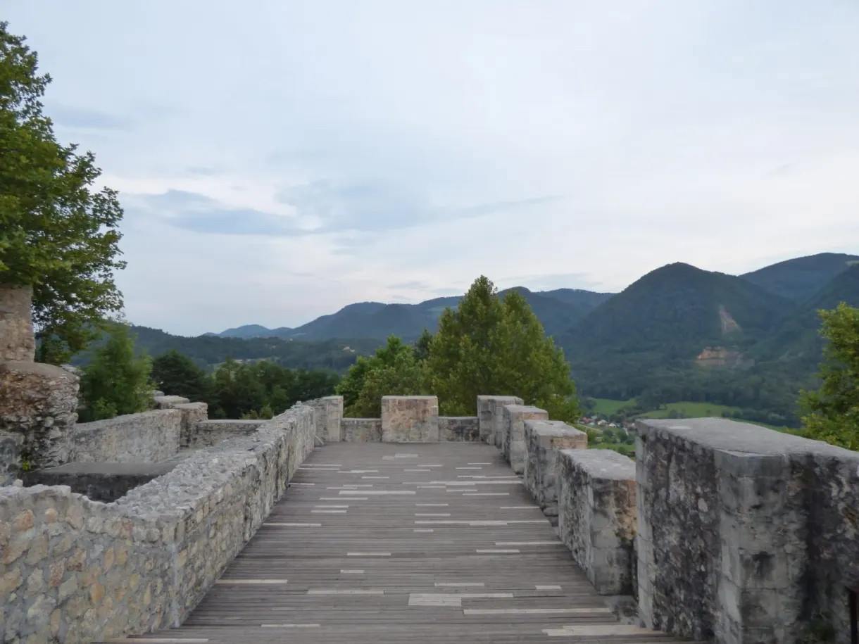 Passerelle de pierre entre deux murets face aux montagnes