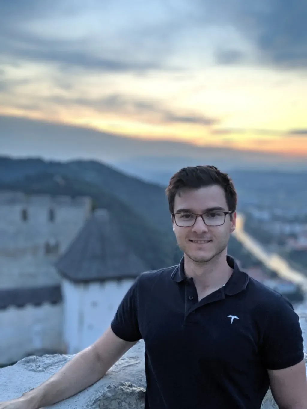 Portrait d'un homme souriant devant le château en arrière-plan