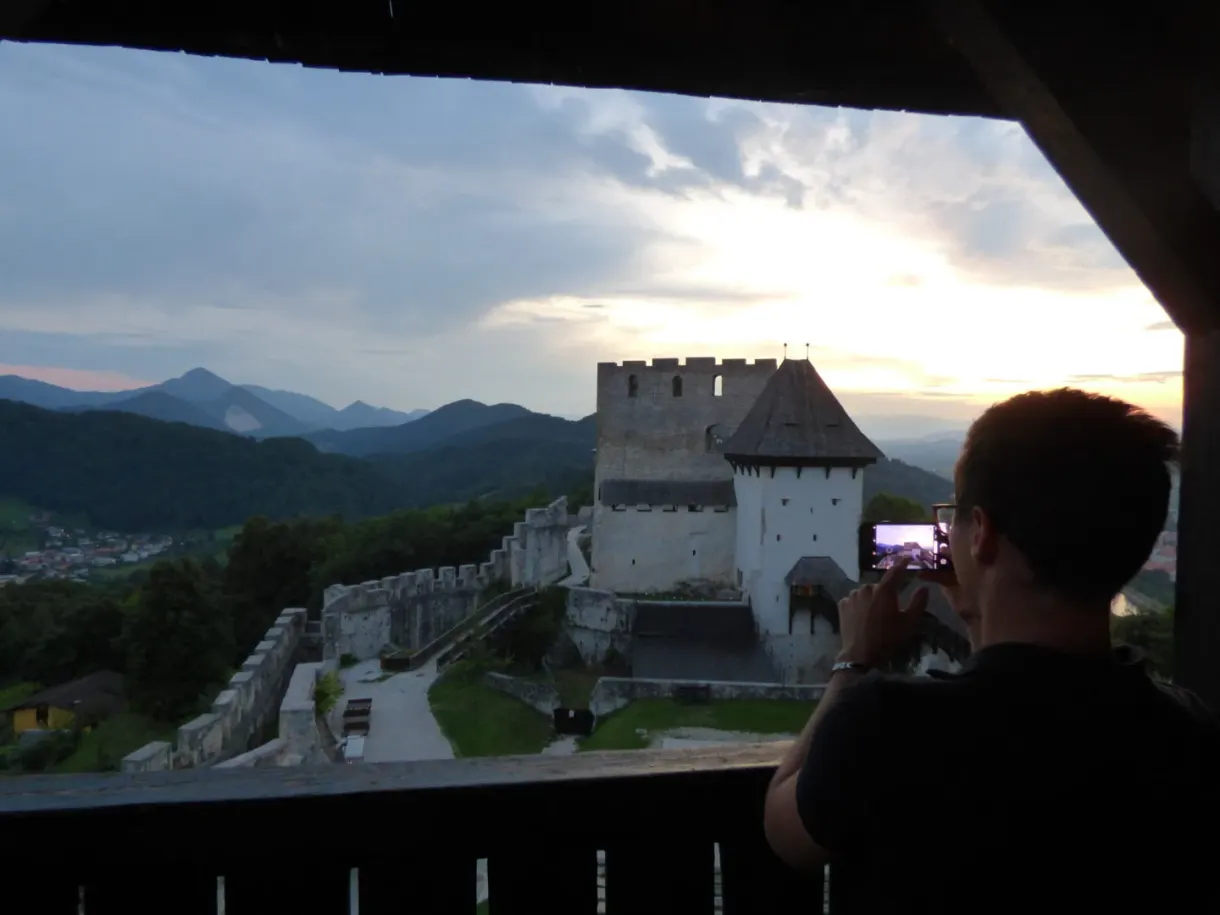 Silhouette photographiant le château depuis une ouverture sombre de la tour