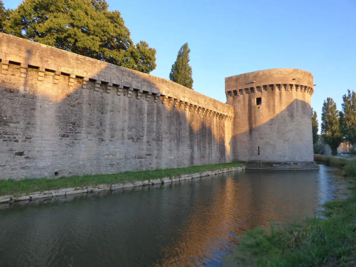 Ramparts gilded by the evening light above the moat
