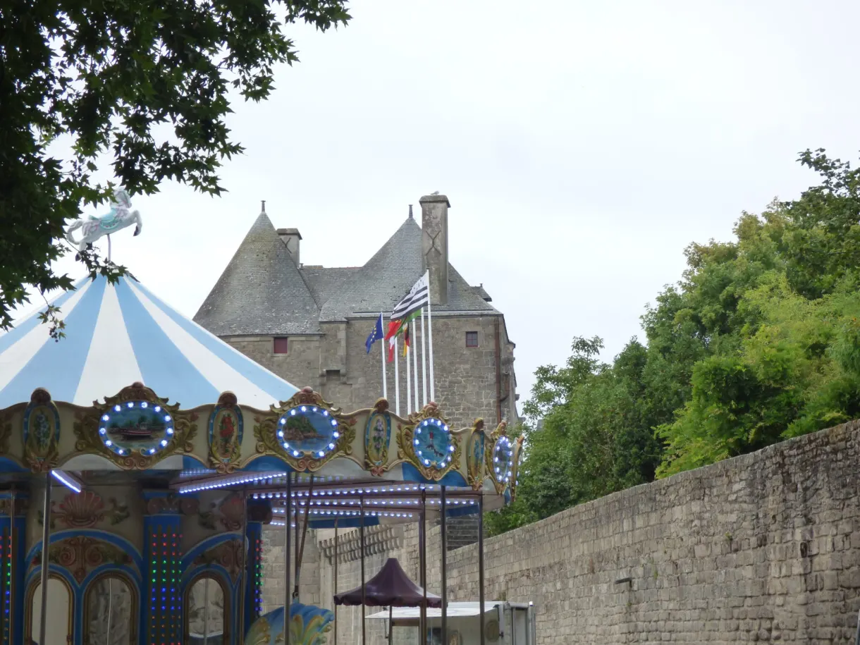 Funfair carousel set up in front of the fortified gate of the town